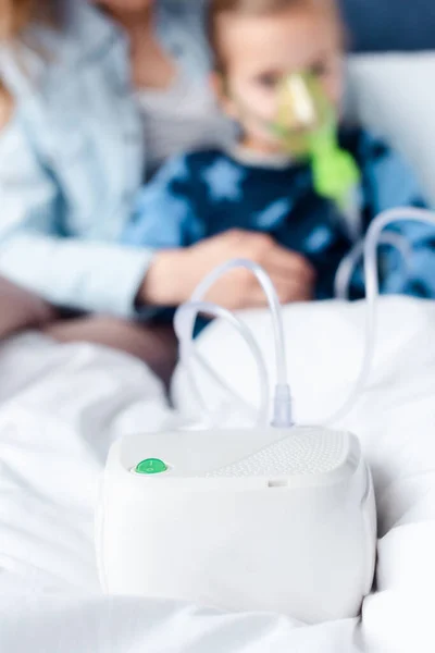 Selektiver Fokus des Kompressorinhalators in der Nähe von asthmatischem Kind und Mutter — Stockfoto
