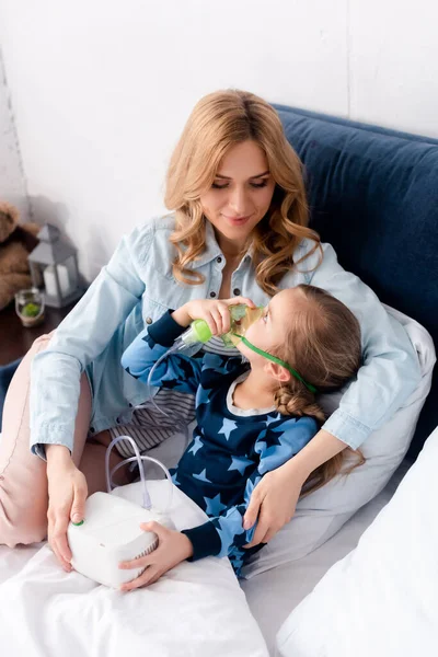 Asthmatisches Kind mit Atemmaske schaut fürsorgliche Mutter an — Stockfoto