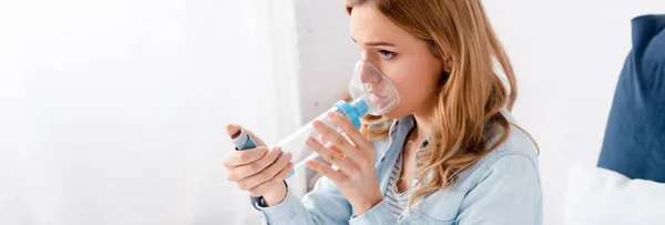 Tiro panorâmico de mulher asmática usando inalador com espaçador — Fotografia de Stock