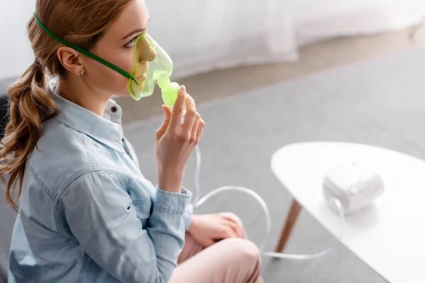 Foco seletivo da mulher asmática em máscara respiratória usando inalador compressor — Fotografia de Stock