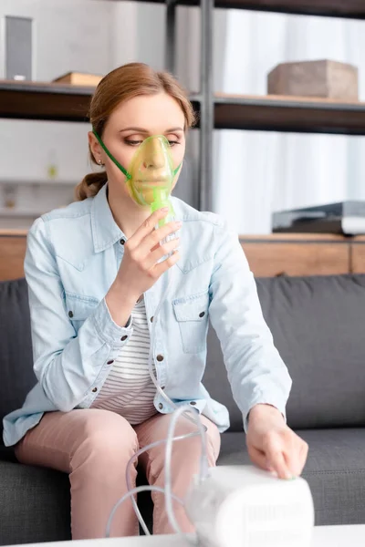 Selective focus of sick woman in respiratory mask using compressor inhaler — Stock Photo