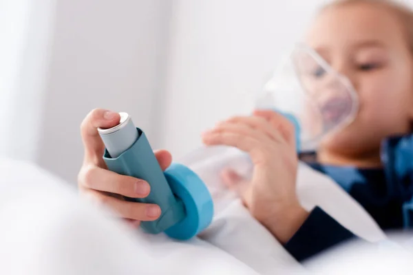 Selektiver Fokus des erkrankten Kindes mittels Inhalator mit Abstandhalter — Stockfoto