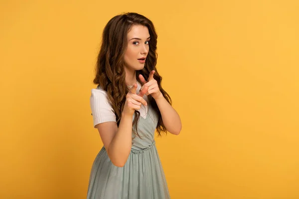 Hermosa mujer de primavera apuntando a usted aislado en amarillo - foto de stock