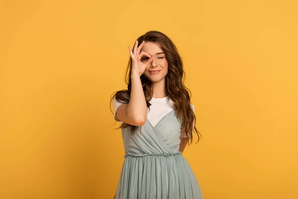 Alegre jovem primavera mulher mostrando ok sinal no amarelo — Fotografia de Stock