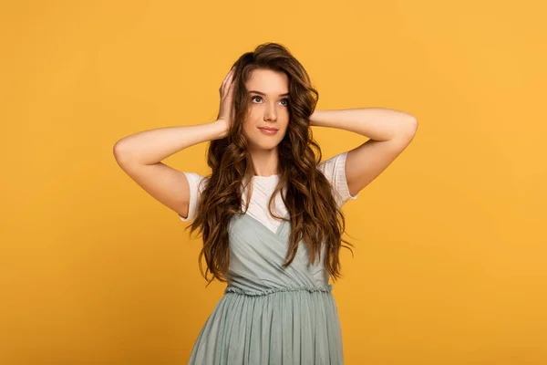 Mujer de primavera atractiva feliz con el pelo largo aislado en amarillo - foto de stock