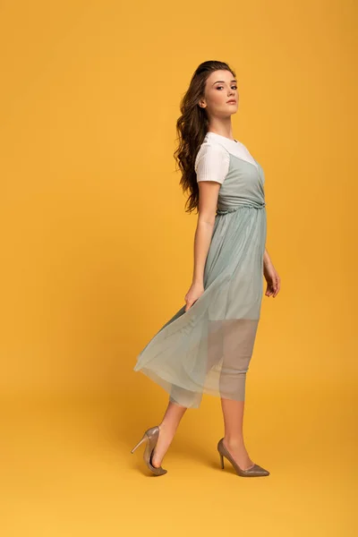 Attractive young spring woman in elegant dress on yellow — Stock Photo