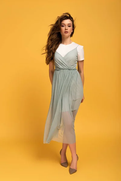 Beautiful girl in t-shirt and dress on yellow — Stock Photo