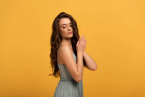 Beautiful tender spring girl with long hair in dress isolated on yellow — Stock Photo