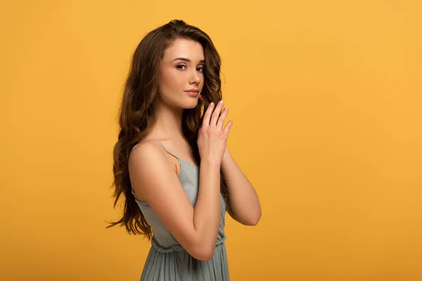 Beautiful elegant spring girl with long hair in dress isolated on yellow — Stock Photo