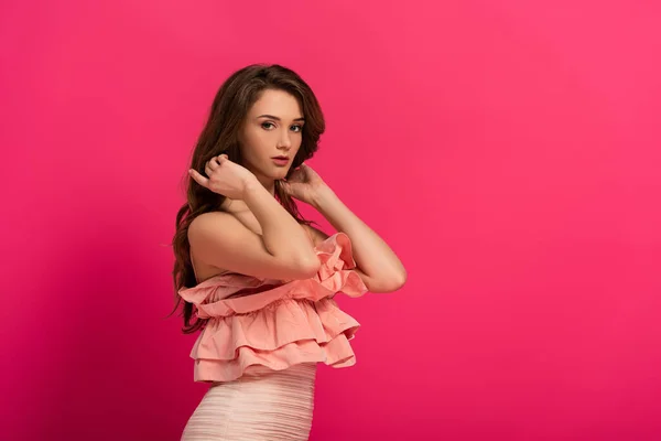 Привлекательная девушка стоит в элегантном платье на розовый — стоковое фото