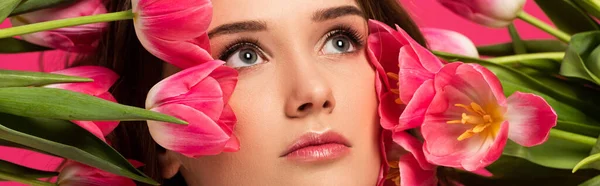 Plano panorámico de hermosa chica con flores de tulipán de primavera aislado en rosa - foto de stock