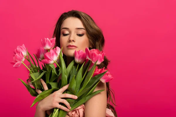 Красива дівчина тримає букет з квітів тюльпанів ізольовані на рожевому — стокове фото