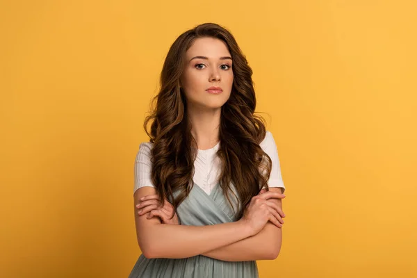 Attractive spring girl with crossed arms on yellow — Stock Photo