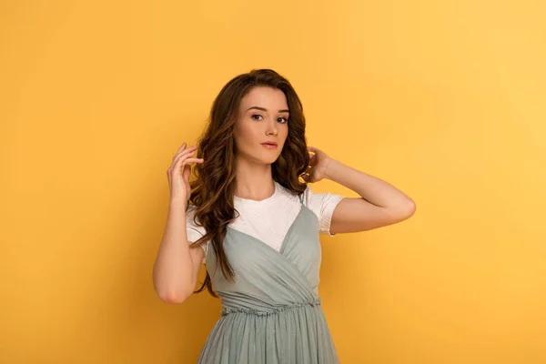 Beautiful young spring woman with long hair on yellow — Stock Photo