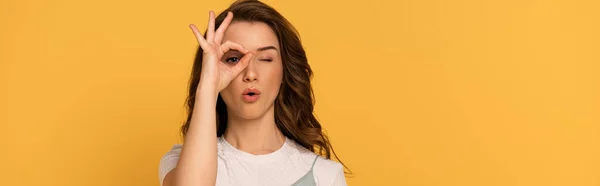 Panoramic shot of shocked spring girl showing ok sign isolated on yellow — Stock Photo