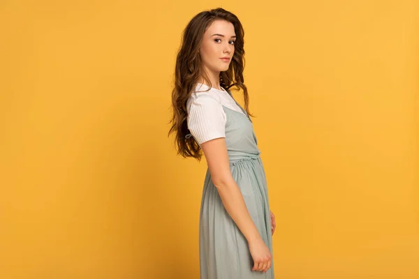 Attractive young spring woman in t-shirt and dress on yellow — Stock Photo