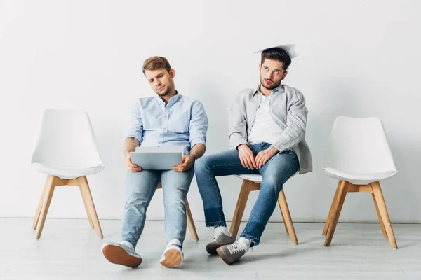 Candidatos exaustos com laptop e currículo à espera de entrevista de emprego no escritório — Fotografia de Stock