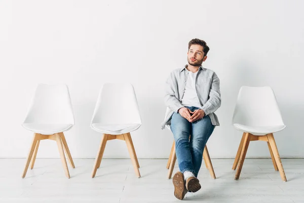 Человек, сидящий на стуле в ожидании набора в офис — стоковое фото
