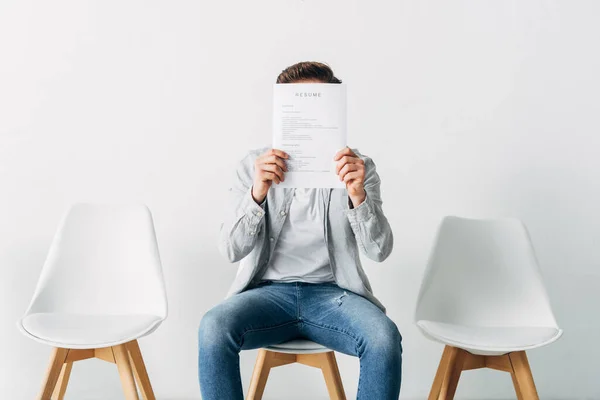 Mann verdeckt Gesicht mit Lebenslauf im Amt — Stockfoto