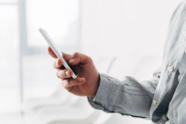 Cropped view employee using smartphone in office — Stock Photo