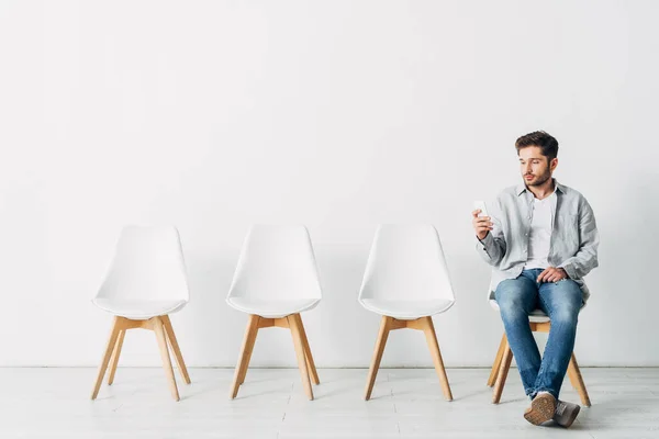 Заявитель использует смартфон в ожидании собеседования — Stock Photo