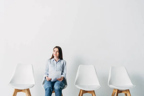 Attraktive Mitarbeiterin mit Lebenslauf schaut auf Stuhl im Büro weg — Stockfoto