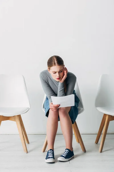 CV de lecture de l'employé confiant assis sur la chaise dans le bureau — Photo de stock