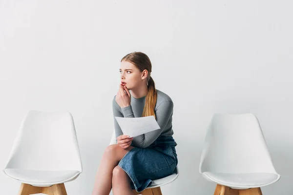 Pensive candidate holding resume while waiting job interview in office — Stock Photo