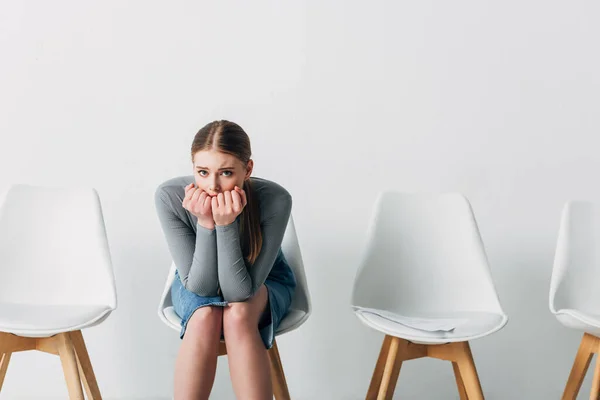 Scared candidate looking at camera near resume on chair in office — Stock Photo