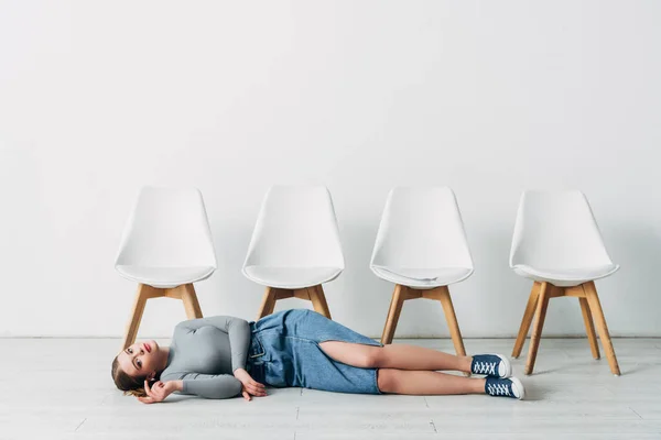 Attractive applicant looking at camera while lying on floor in office — Stock Photo