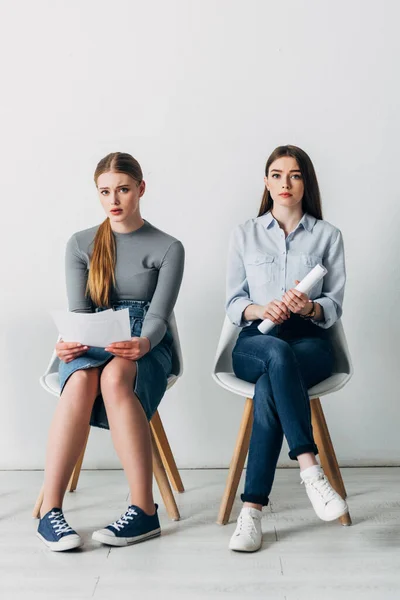 Employés attrayants avec CV regardant la caméra sur les chaises dans le bureau — Photo de stock