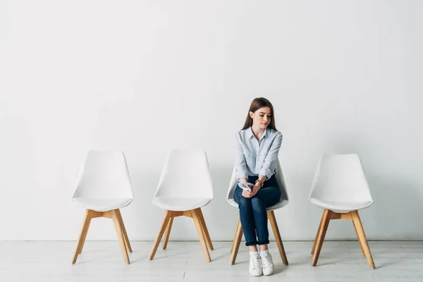 Hermoso empleado con curriculum vitae sentado en la silla en la oficina - foto de stock