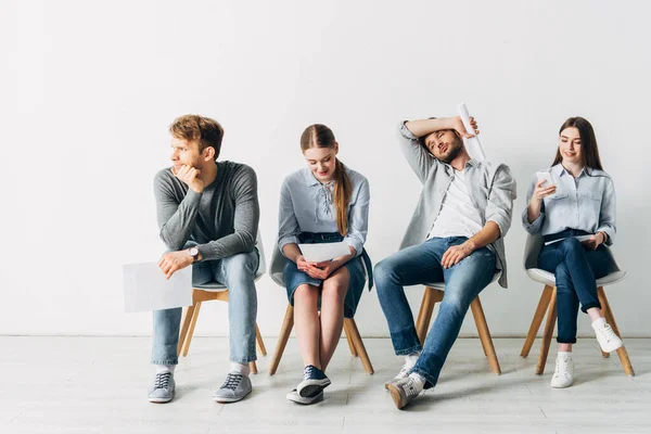 Group of employees with resume sitting on chairs in office — Stock Photo