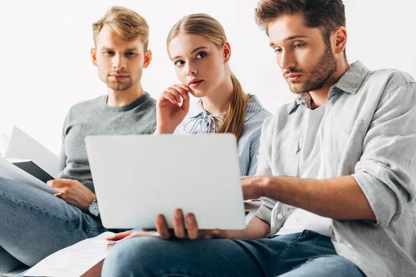 Enfoque selectivo de los empleados con CV mirando a la computadora portátil en la oficina - foto de stock