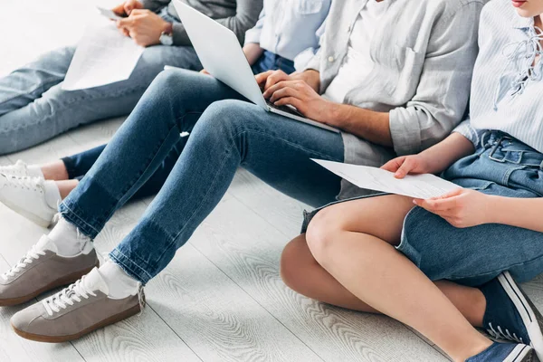 Cropped view of applicants with resume and gadgets sitting on floor — Stock Photo