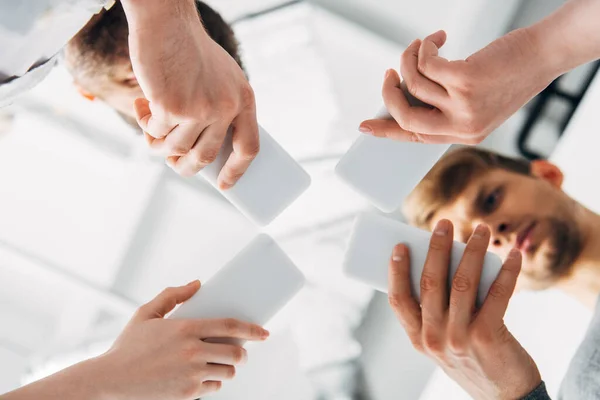 Bottom view of young people using smartphones — Stock Photo