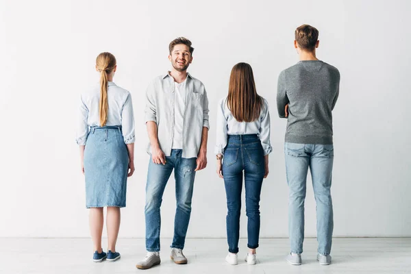 Lächelnder Mann blickt in die Kamera in der Nähe von Mitarbeitern im Büro — Stockfoto