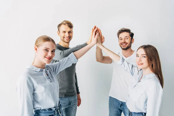 Young coworkers smiling at camera while high five in office — Stock Photo