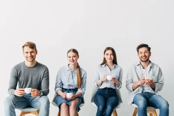 Confrères joyeux souriant à la caméra tout en buvant du café ensemble — Photo de stock