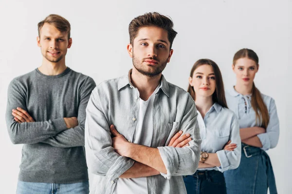 Selective focus of coworkers with crossed arms looking at camera in office — Stock Photo