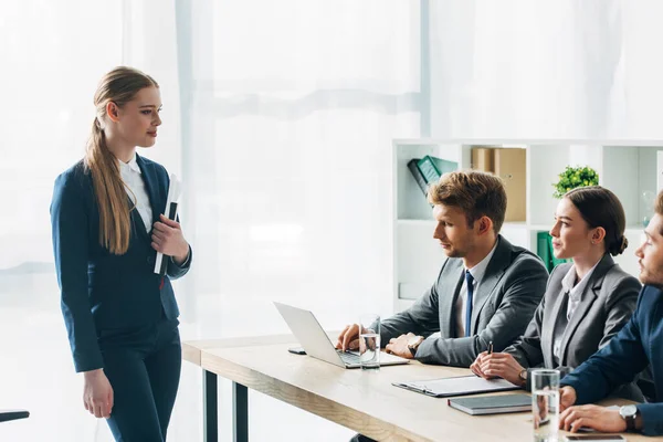 Foco seletivo do funcionário olhando para os recrutadores com área de transferência e laptop na mesa — Fotografia de Stock