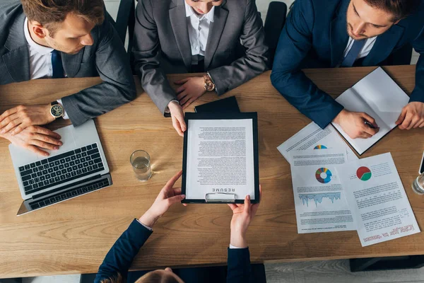 Overhead view of employee holding resume near recruiters at table — Stock Photo