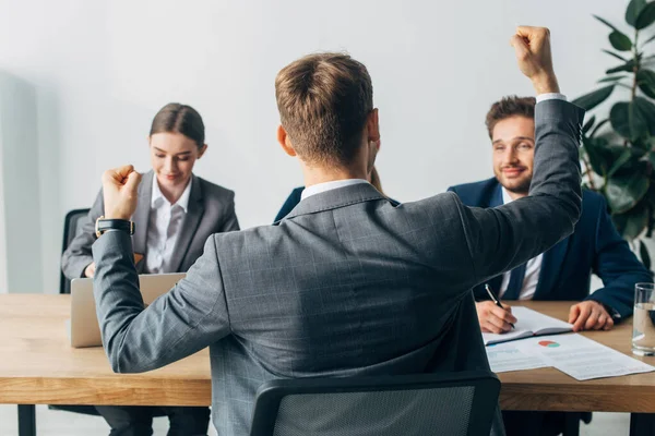 Selective focus of employee showing yes gesture near recruiters at table — Stock Photo