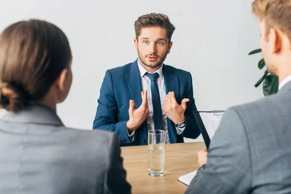 Enfoque selectivo del empleado que se señala a sí mismo durante la entrevista de trabajo con los reclutadores - foto de stock