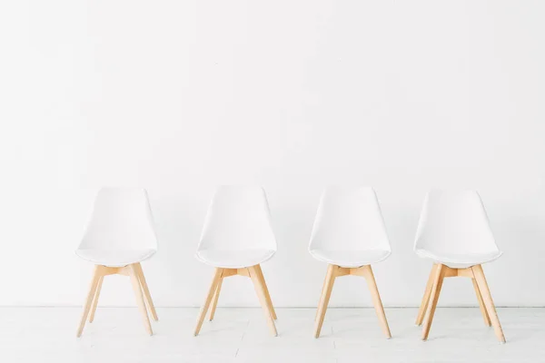 Row of chairs near white wall in office — Stock Photo