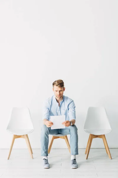 Employee holding resume while sitting in office — Stock Photo