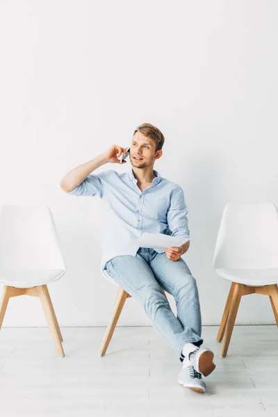 Сотрудник разговаривает на смартфоне и держит резюме в офисе — Stock Photo