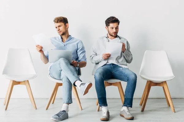 Employees with gadgets and resume waiting for job interview in office — Stock Photo