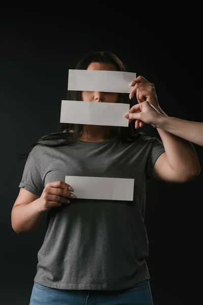 Vue de face de jeune taille plus femme cachant visage sous des cartes vides sur fond noir — Photo de stock