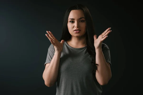Front view of irritated plus size girl gesturing on black background — Stock Photo